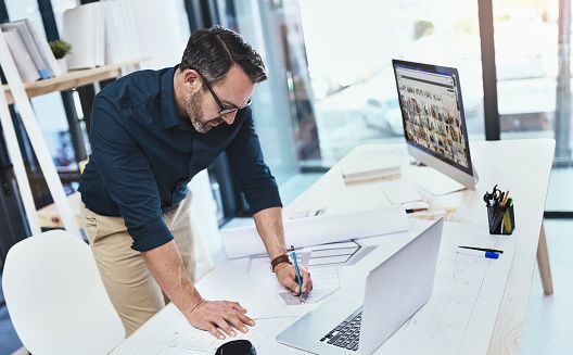 Shot of a mature male architect working on his laptop